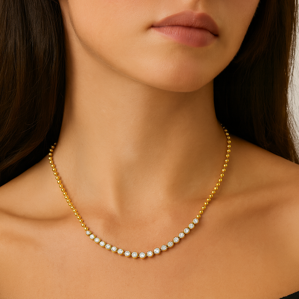 Close-up of a person wearing a gold necklace with a blurred background