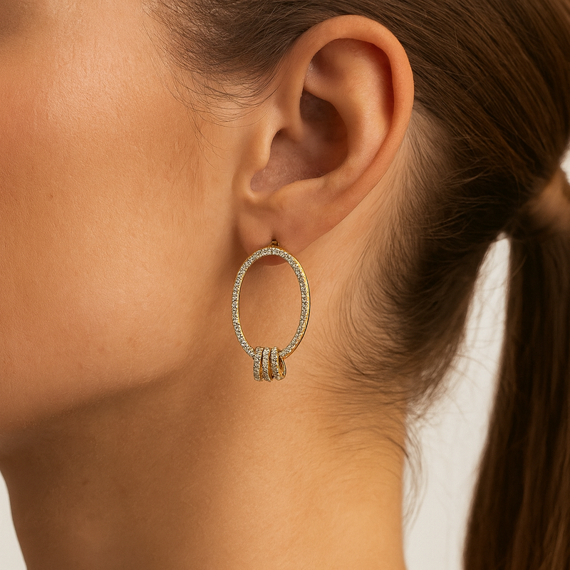 Close-up of a person wearing a gold hoop earring with a blurred background