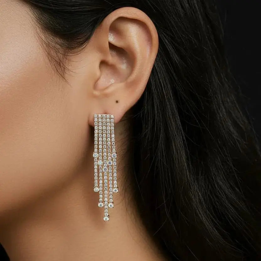 Close-up of a person wearing a dangling earring with a dark background